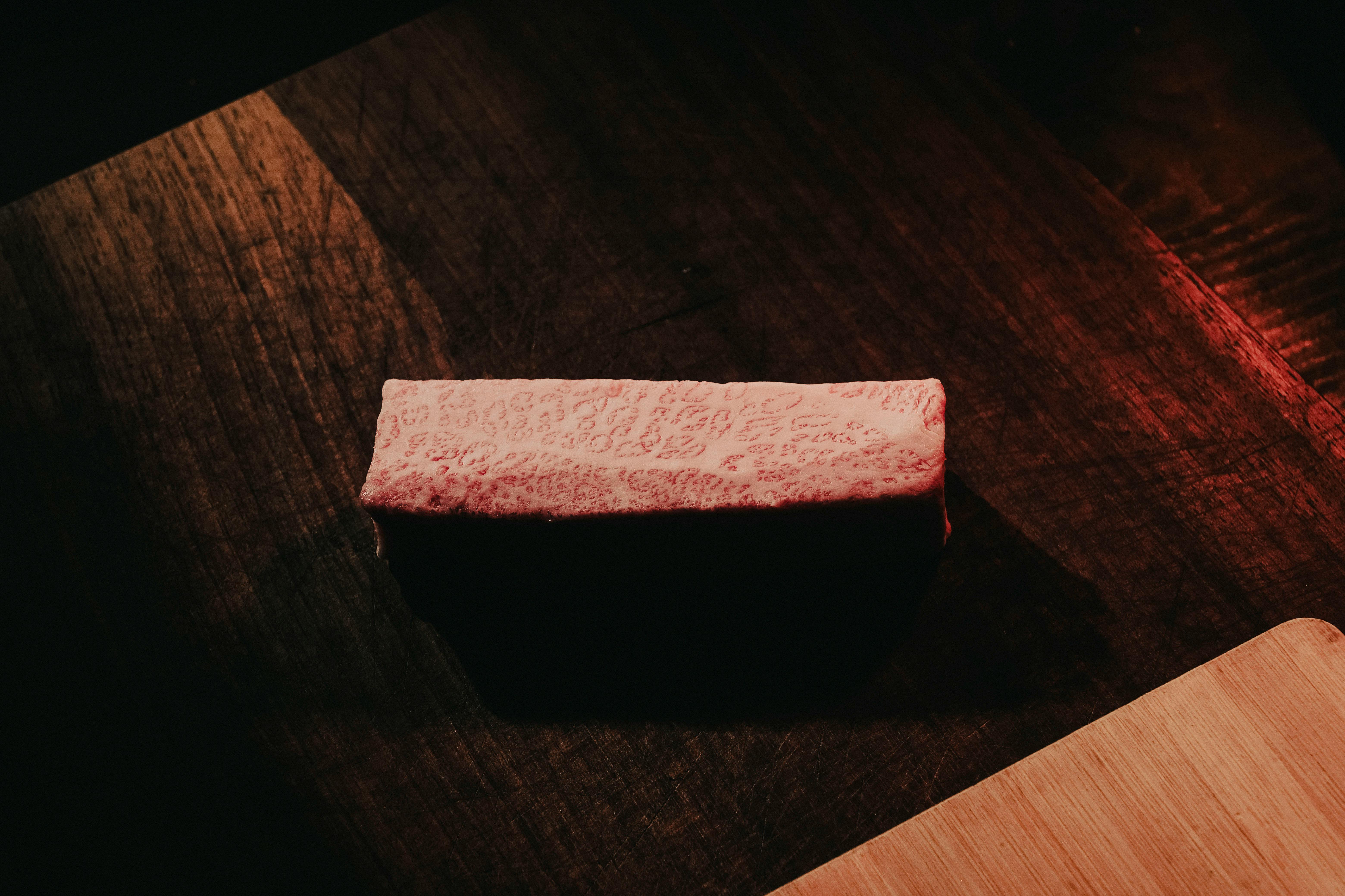 Fresh raw beef steak on black plate.